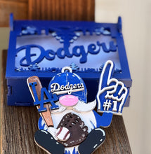 Gnome with Dodgers hat and glove, holding a bat and number one sign, in front of a blue 'Dodgers' sign.